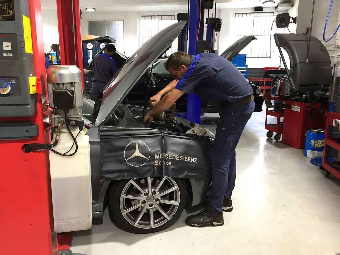 Technician servicing a Mercedes-Benz on the hoist at Phillip Lim Automotive
