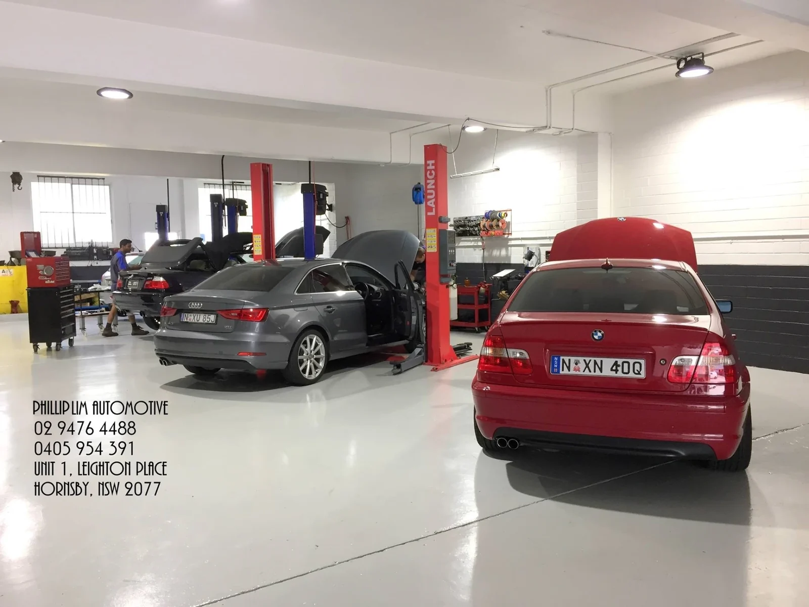 Audi and BMW on the hoists in the Phillip Lim Automotive workshop, Hornsby